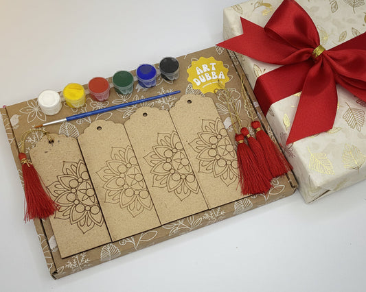 Art Dubba kits with paint, brushes, and decorative tags next to a wrapped gift with a red bow.