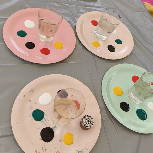 Art party prep with four plates on the table filled with paints 
