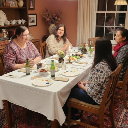Group of people gathered around a table with art supplies in a casual setting.