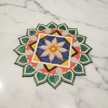 Colourful floral design Mandala on a tablecloth with a mug and paintbrushes.