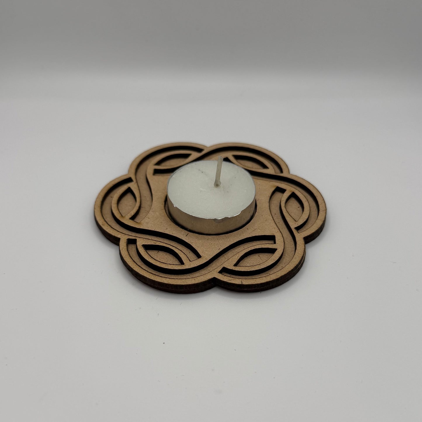 Decorative wall clock with intricate design on a plain white wall.