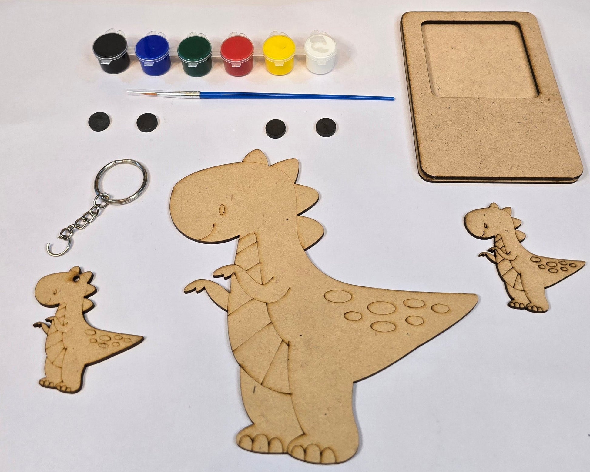 Art Dubba craft kit with dinosaur shapes, paint, and brush on a white background