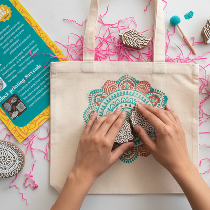 Person decorating a tote bag with mandala designs on a marble surface with art supplies.