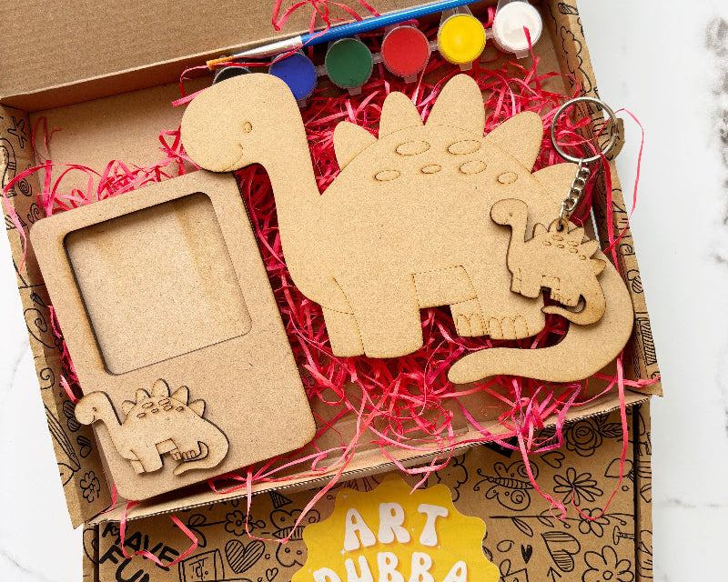 Art Dubba craft kit with wooden dinosaur shapes and supplies in a box.