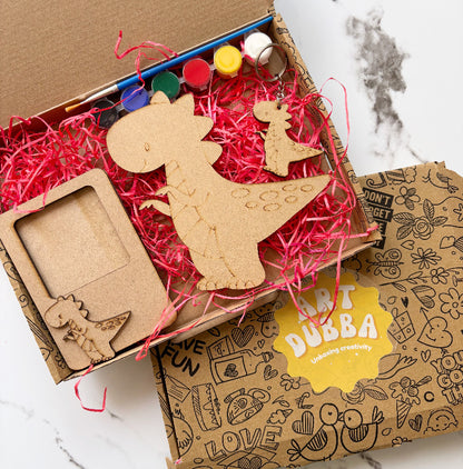 Wooden dinosaur toys and a photo frame in a box with 'Art Dubba' branding.
