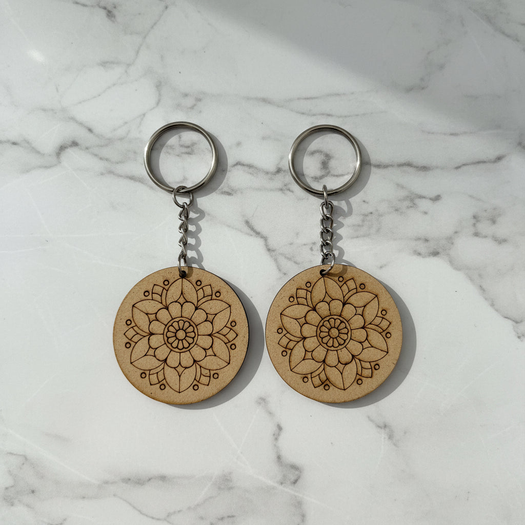Two wooden keychains with intricate designs on a white background