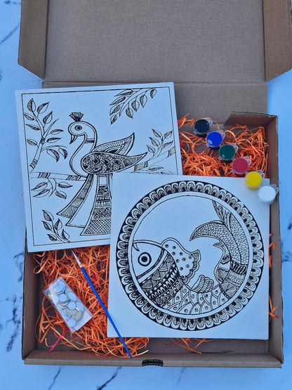 Open cardboard box with mandala art cards and decorative items on a light blue surface.